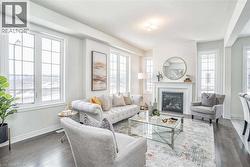 Living room with baseboards, a glass covered fireplace, and wood finished floors - 