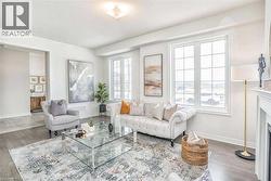 Living room with baseboards, wood finished floors, and a fireplace - 