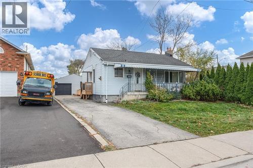 View of front of house featuring an outbuilding, a garage, and a front lawn - 99 East 36Th Street, Hamilton, ON - Outdoor With Deck Patio Veranda
