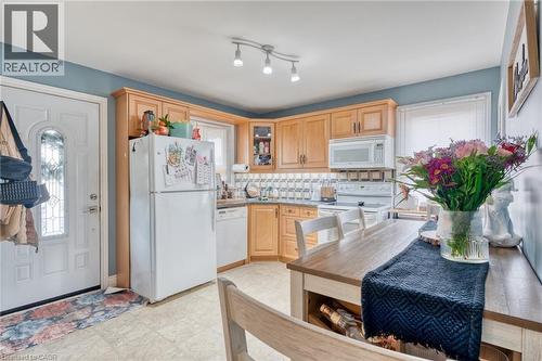 Kitchen with light brown cabinets, white appliances, and tasteful backsplash - 99 East 36Th Street, Hamilton, ON - Indoor Photo Showing Kitchen