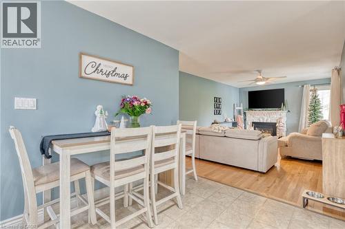 Dining room featuring a fireplace, wood-type flooring, and ceiling fan - 99 East 36Th Street, Hamilton, ON - Indoor With Fireplace