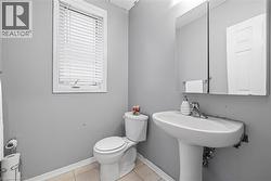 Half bath featuring light tile patterned floors and toilet - 