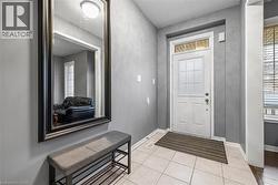 Foyer featuring light tile patterned flooring and baseboards - 