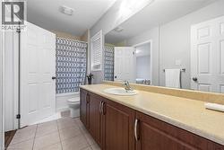 Full bathroom with vanity, light tile patterned floors, and shower / tub combo with curtain - 