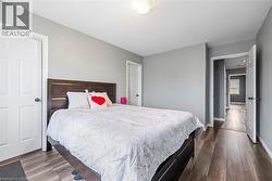 Bedroom with dark wood-style flooring and baseboards - 