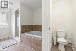 Full bath featuring a bath, a stall shower, and tile patterned floors - 