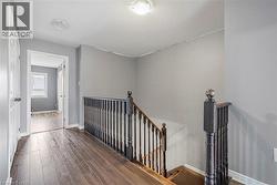 Hallway with an upstairs landing, dark wood-type flooring, and a textured ceiling - 