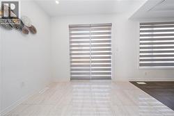 Tiled empty room featuring baseboards - 