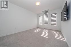 Spare room featuring carpet floors and baseboards - 
