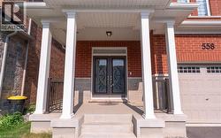 Entrance to property with covered porch, a garage, brick siding, and french doors - 