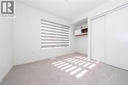 Unfurnished bedroom with light colored carpet and a closet - 