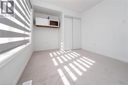 Unfurnished bedroom with light colored carpet and a closet - 