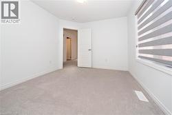 Spare room featuring light carpet and baseboards - 