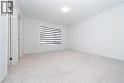 Unfurnished bedroom with light carpet and baseboards - 