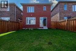 Back of house featuring brick siding and a fenced backyard - 