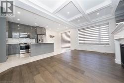 Unfurnished living room featuring light wood-style flooring, coffered ceiling, a fireplace, recessed lighting, and beam ceiling - 