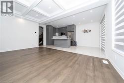 Unfurnished living room featuring light wood finished floors, coffered ceiling, recessed lighting, and beamed ceiling - 