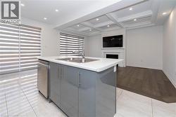 Kitchen with light countertops, coffered ceiling, a kitchen island with sink, beam ceiling, and open floor plan - 