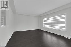 Spare room featuring plenty of natural light and dark wood-style flooring - 