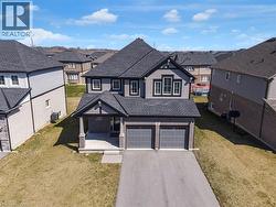 View of front of house with a shingled roof, a residential view, a front yard, and asphalt driveway - 