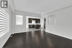 Unfurnished living room featuring dark wood finished floors - 