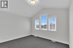 Empty room with lofted ceiling and carpet flooring - 