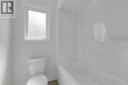 Bathroom with shower / washtub combination and light tile patterned flooring - 