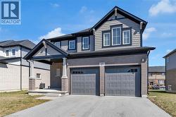Craftsman inspired home featuring driveway, a front yard, an attached garage, and brick siding - 