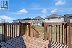 Wooden deck featuring a residential view, a yard, and a grill - 