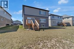 Rear view of property with a residential view, a yard, and stairs - 