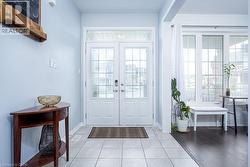 Doorway featuring baseboards, french doors, and light tile patterned floors - 