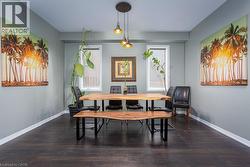 Dining space with wood finished floors, a healthy amount of sunlight, and baseboards - 