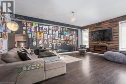 Living room featuring wood finished floors, an accent wall, and a healthy amount of sunlight - 