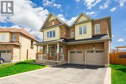 Craftsman-style house featuring driveway, covered porch, fence, brick siding, and an attached garage - 