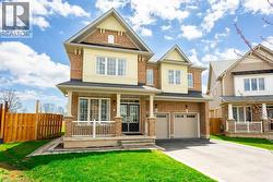 Craftsman inspired home featuring a front lawn, driveway, fence, a porch, and a garage - 