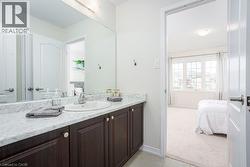 Ensuite bathroom with connected bathroom, baseboards, vanity, and tile patterned floors - 