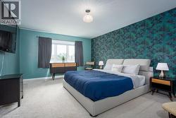 Carpeted bedroom with wallpapered walls, baseboards, and an accent wall - 