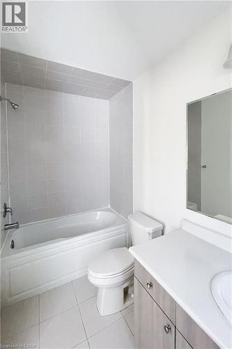 Bathroom featuring bathtub / shower combination, vanity, and light tile patterned floors - 116 Watermill Street, Kitchener, ON - Indoor Photo Showing Bathroom