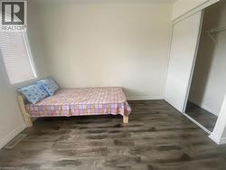 Bedroom featuring dark wood-style flooring and a closet - 