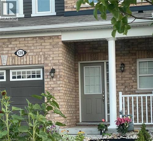 View of exterior entry featuring a porch, a shingled roof, and stone siding - 128 Watermill Street, Kitchener, ON - Outdoor
