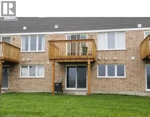 Back of property with a balcony, brick siding, and a lawn - 128 Watermill Street, Kitchener, ON - Outdoor With Exterior