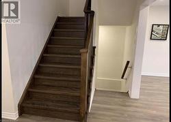 Stairway featuring baseboards and wood finished floors - 