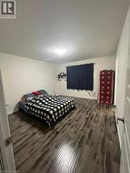 Bedroom with dark wood-type flooring and baseboards - 