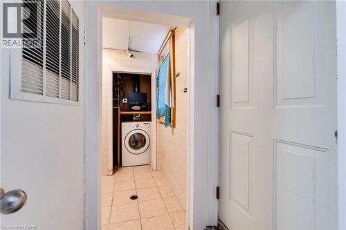 Washroom with washer / clothes dryer and tile patterned floors - 18 Barton Street E Unit# A, Hamilton, ON 