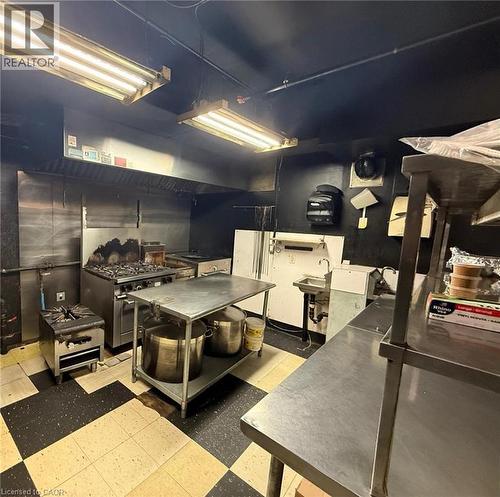 Kitchen with stainless steel range with gas stovetop and dark cabinetry - 179 King Street W, Kitchener, ON 