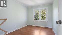 Spare room featuring light wood-style flooring and crown molding - 