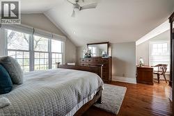 Bedroom featuring lofted ceiling, hardwood / wood-style floors, a ceiling fan, and recessed lighting - 