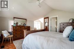 Bedroom featuring vaulted ceiling, wood finished floors, and ceiling fan - 