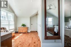 Bedroom featuring vaulted ceiling, light wood-style floors, multiple windows, and recessed lighting - 