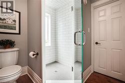 Bathroom 3-pc featuring a shower stall and dark wood-style flooring - 